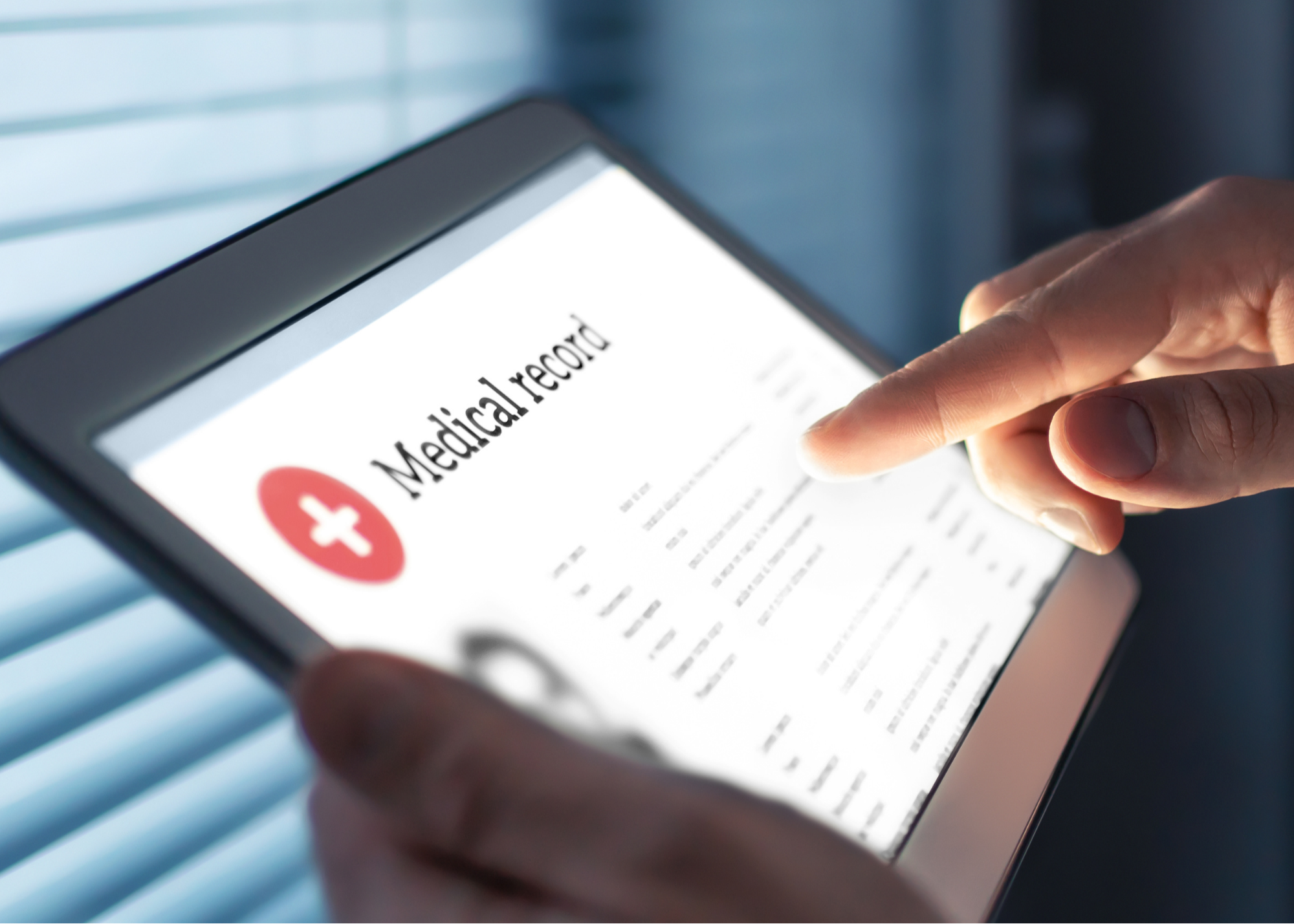 Close-up of a hand interacting with a tablet displaying a medical record, signifying the use of technology in modern healthcare management.
