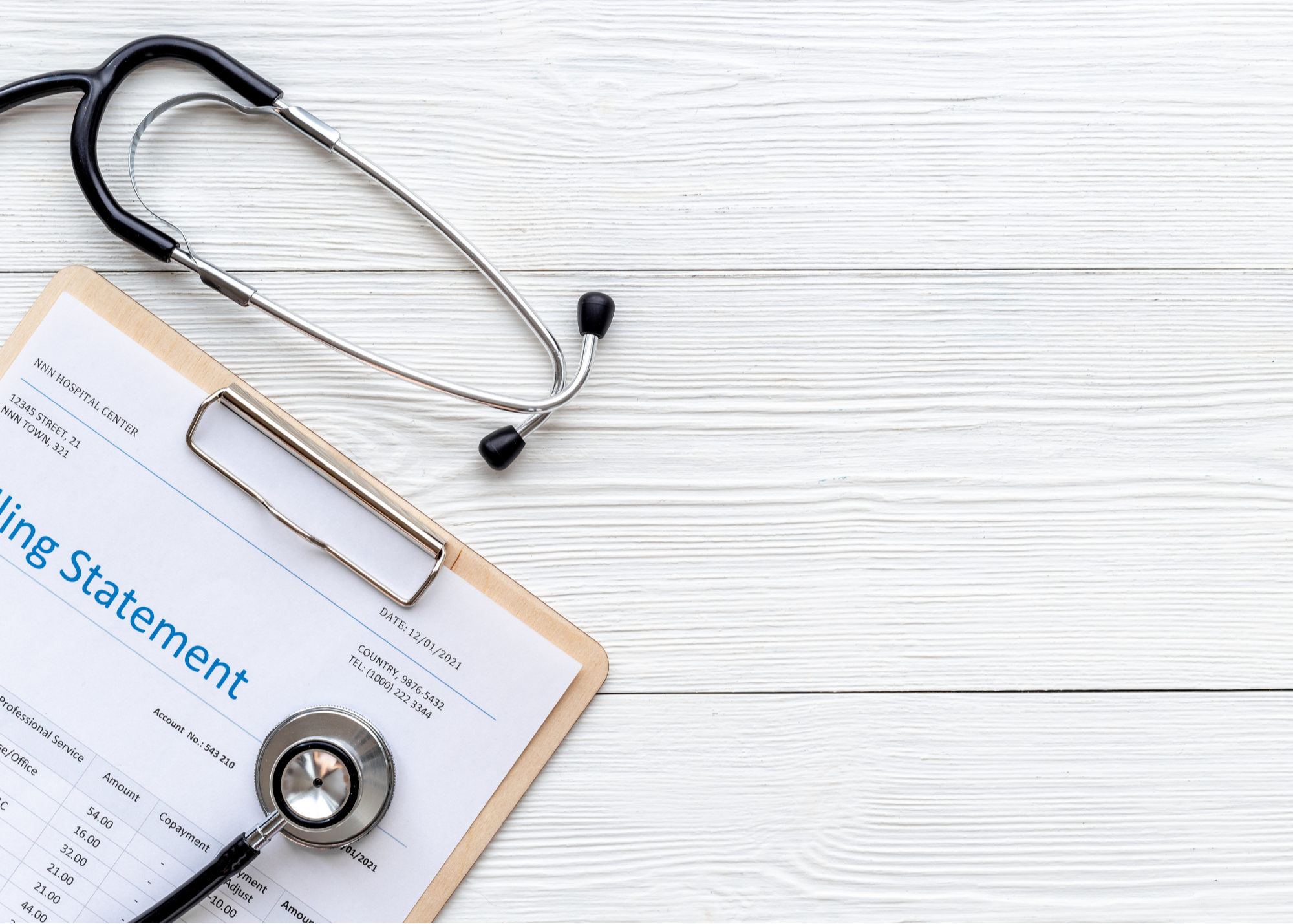 A stethoscope and a billing statement on a clipboard lie on a white wooden surface, symbolizing healthcare administration.
